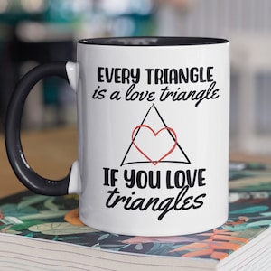 May include: White ceramic mug with a black handle and black rim. The mug has a black and red graphic that says "Every triangle is a love triangle. If you love triangles."