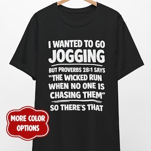 May include: A black short-sleeved t-shirt featuring white text that reads: I WANTED TO GO JOGGING BUT PROVERBS 28:1 SAYS THE WICKED RUN WHEN NO ONE IS CHASING THEM SO THERE'S THAT. A red badge on the lower left displays the text MORE COLOR OPTIONS.