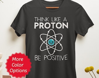 T-shirt Pensez comme un proton, soyez positif, cadeau de chimie drôle, t-shirt de jeu de mots pour professeur de chimie, particules atomiques cadeau de physique des neutrons électroniques