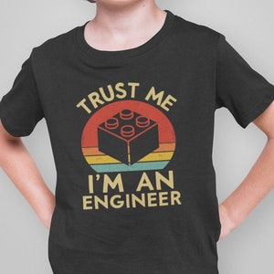 May include: Black t-shirt with a vintage-style graphic of a Lego brick and the text "Trust me I'm an engineer".