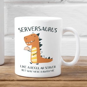 Może przedstawiać: Biały ceramiczny kubek z brązowym dinozaurem trzymającym tacę. Tekst "Serversaurus" jest nadrukowany czarnym kolorem na górze kubka. Pod dinozaurem, tekst "Like a regular server but way more rawrsome" jest nadrukowany czarnym kolorem.
