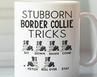 May include: White ceramic mug featuring the text "STUBBORN BORDER COLLIE TRICKS" and images of a Border Collie demonstrating tricks. The tricks are sit, down, shake, come, fetch, roll over, and stay. The mug has a white handle.