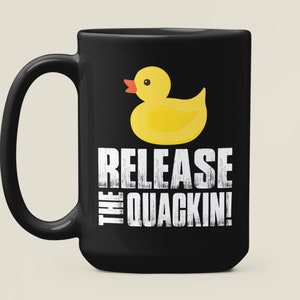 May include: Black coffee mug with a yellow rubber duck and the text "Release the Quackin!" in white.