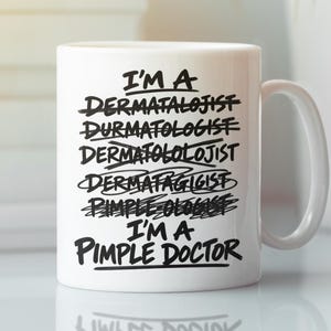 May include: A white ceramic mug featuring black text that reads: I'M A DERMATALOJIST, DURMATOLOGIST, DERMATOLOLOJIST, DERMATAGIGIST, PIMPLE OLOGIST, I'M A PIMPLE DOCTOR. Each incorrect spelling is crossed out with a black line, leaving the final line clear.