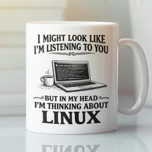 May include: A white ceramic mug featuring black text that reads, I MIGHT LOOK LIKE I'M LISTENING TO YOU, followed by an illustration of a laptop and a coffee cup, and the text, BUT IN MY HEAD I'M THINKING ABOUT LINUX, printed on the front.