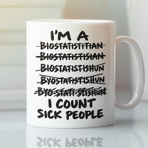 Puede incluir: Una taza de cerámica blanca con texto negro que dice: I'M A, seguido de varios intentos tachados de escribir la palabra biostatistician, y finalmente la frase I COUNT SICK PEOPLE impresa en letras mayúsculas negritas y claras.