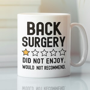 May include: White ceramic coffee mug with black text that reads "BACK SURGERY ☆☆☆☆☆ DID NOT ENJOY. WOULD NOT RECOMMEND."