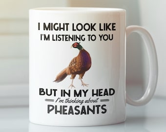 May include: White ceramic coffee mug with a black and white graphic of a pheasant. The text on the mug reads "I might look like I'm listening to you, but in my head I'm thinking about pheasants."