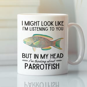 May include: White ceramic mug with a black and white graphic of a parrotfish and the text "I might look like I'm listening to you but in my head I'm thinking about parrotfish".