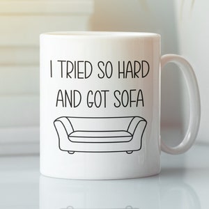 May include: White ceramic mug with a black outline of a couch and the text "I tried so hard and got sofa".