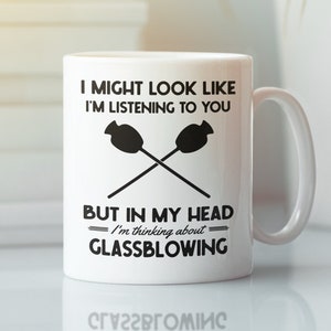 May include: White ceramic mug with a black graphic that reads "I might look like I'm listening to you, but in my head I'm thinking about glassblowing".