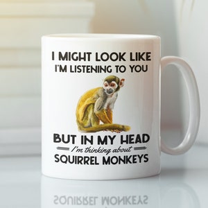 May include: White ceramic mug with a black and white graphic of a squirrel monkey. The text on the mug reads "I might look like I'm listening to you, but in my head I'm thinking about squirrel monkeys."