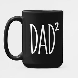 May include: A black ceramic coffee mug with a large, curved handle. The mug features the white text "DAD²" in a bold, sans-serif font, making it a perfect gift for Father's Day or any occasion.