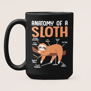 Peut inclure: Mug à café noir avec un graphique blanc d'un paresseux avec le texte "Anatomie d'un paresseux" et des étiquettes pour différentes parties du corps du paresseux.