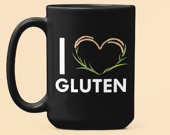 May include: Black coffee mug with a white graphic that says "I love gluten" with a heart shape made of wheat stalks.