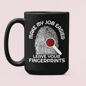 May include: Black coffee mug with a white fingerprint design and the text "Make my job easier leave your fingerprints".