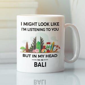 May include: White ceramic mug with a black graphic that says "I might look like I'm listening to you, but in my head I'm in Bali". The graphic includes a stylised image of a Balinese temple and beach scene.