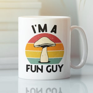 May include: White ceramic mug with a retro-style design featuring a mushroom and the text "I'm a Fun Guy".