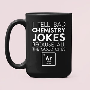 Könnte beinhalten: Schwarze Kaffeetasse mit weißem Text, der "I tell bad chemistry jokes because all the good ones Ar" lautet, mit dem chemischen Symbol für Argon darunter.