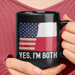 May include: A black coffee mug with a distressed American flag and Polish flag design. The mug has the text "YES, I'M BOTH" printed on it.