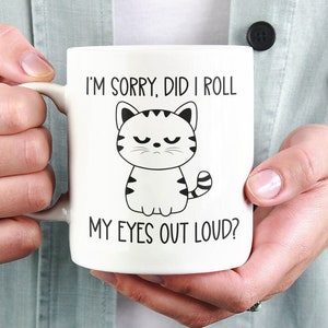May include: White ceramic coffee mug with a black and white illustration of a cat with the text "I'm sorry, did I roll my eyes out loud?"