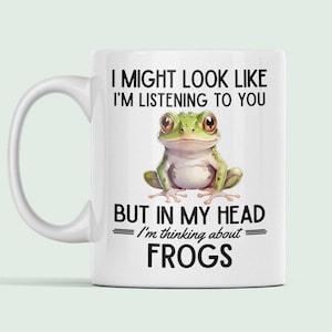 May include: White ceramic mug with a green frog illustration and the text "I might look like I'm listening to you but in my head I'm thinking about FROGS".