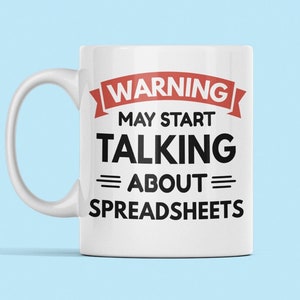 Puede incluir: Taza de cerámica blanca con un diseño rojo y negro. El texto en la taza dice "WARNING MAY START TALKING ABOUT SPREADSHEETS".