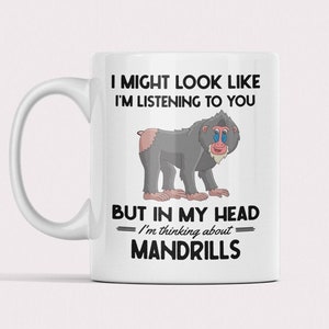 May include: White ceramic mug with a black and white cartoon mandrill and the text "I might look like I'm listening to you, but in my head I'm thinking about mandrills."