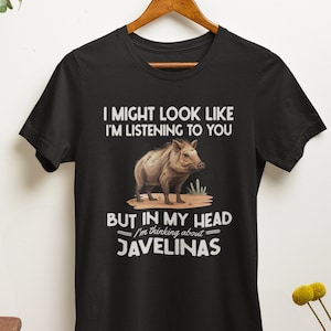 May include: Black t-shirt with a white graphic of a wild pig and the text "I might look like I'm listening to you, but in my head I'm thinking about Javelinas."