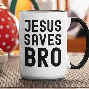 May include: White ceramic coffee mug with a black handle and black text that reads "JESUS SAVES BRO".