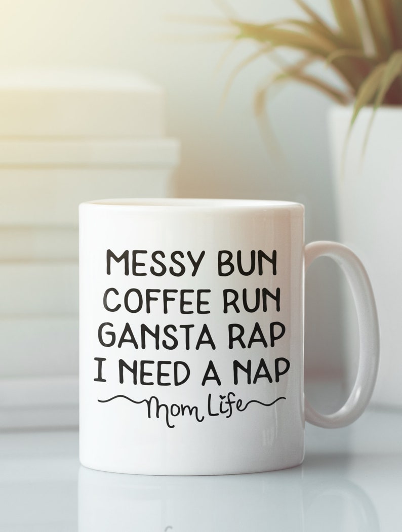 Pode incluir: Caneca de caf&eacute; de cer&acirc;mica branca com texto preto que diz "Messy Bun Coffee Run Gansta Rap I Need A Nap Mom Life".
