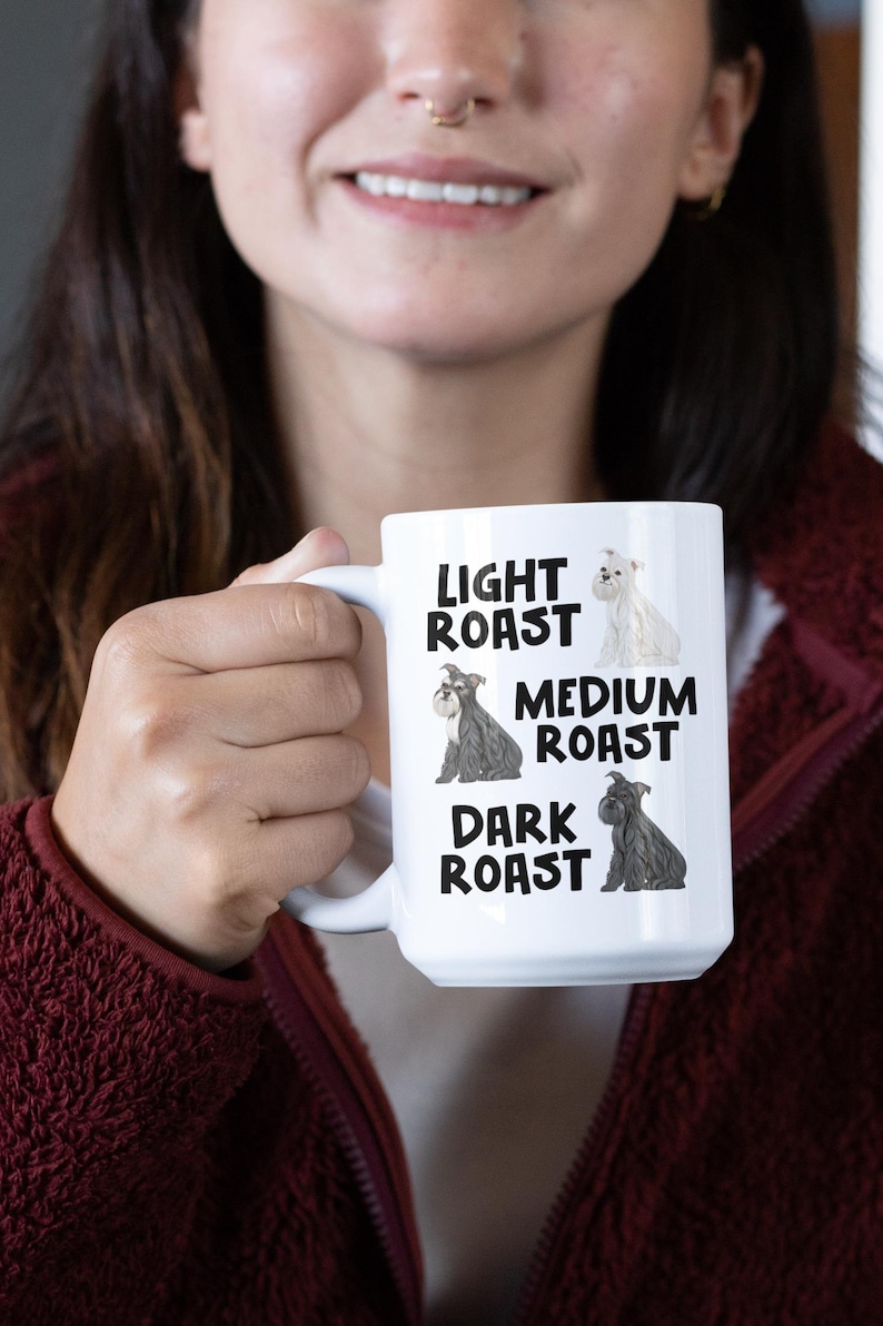 May include: White ceramic mug with a black and white illustration of a dog. The mug has the text "Light Roast", "Medium Roast", and "Dark Roast" with a dog illustration for each roast.