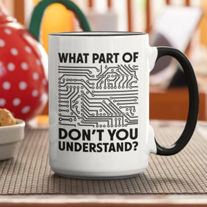 Könnte beinhalten: Weiße Keramiktasse mit schwarzem Rand und Henkel. Die Tasse hat ein schwarzes Leiterplatten-Design und den Text "WHAT PART OF DON'T YOU UNDERSTAND?"