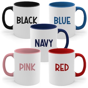 May include: Five ceramic mugs with different coloured rims and text. The mugs are black, blue, navy, pink, and red. The text on the mugs reads "BLACK", "BLUE", "NAVY", "PINK", and "RED".