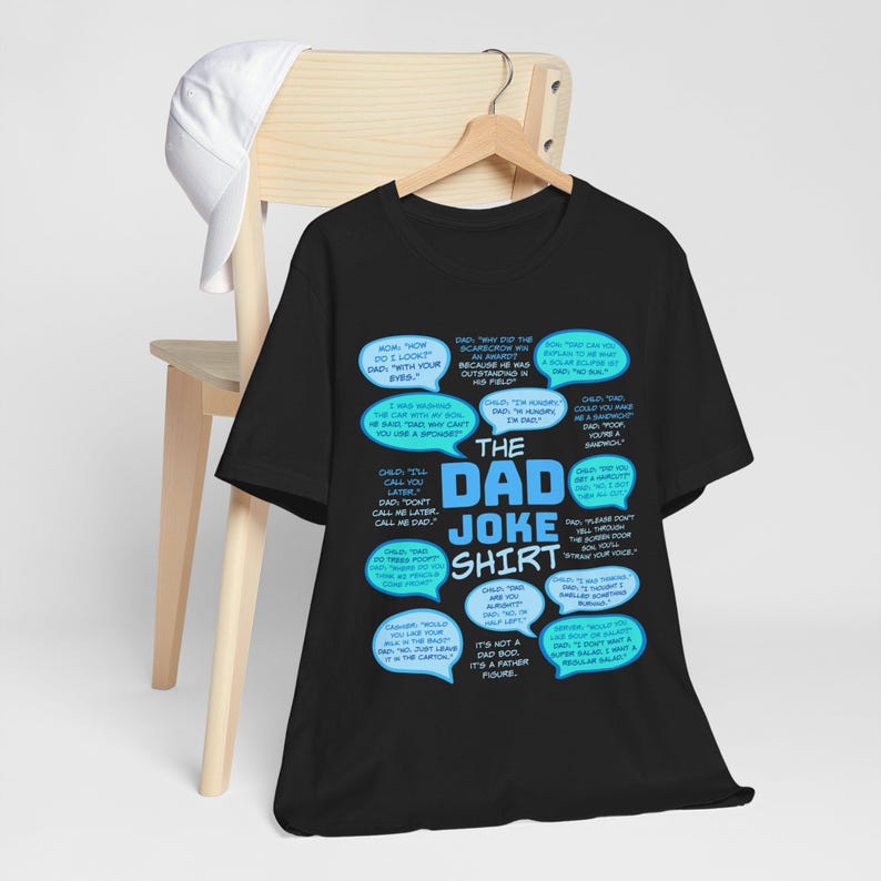 May include: Black t-shirt with a blue and white graphic print of a collection of dad jokes. The text on the shirt reads "The Dad Joke Shirt".