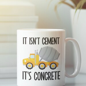 May include: White ceramic mug with a yellow cement truck and the text "It isn't cement, it's concrete".