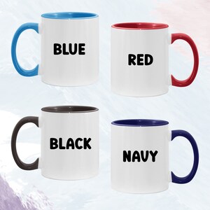 May include: Four ceramic coffee mugs with different coloured rims. The mugs are white with black text. The text on the mugs reads "BLUE", "RED", "BLACK", and "NAVY".