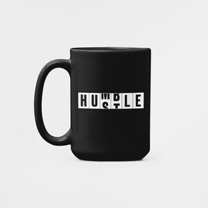 Peut inclure: Mug en c&eacute;ramique noire avec un motif blanc qui dit "HUSTLE" dans un style de tuile de scrabble.