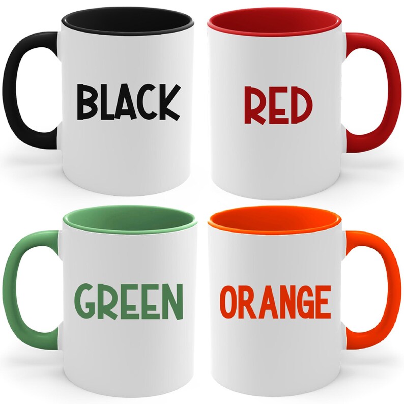 May include: Four ceramic mugs with different colored rims. The mugs are white with black, red, green, and orange rims. The words "BLACK", "RED", "GREEN", and "ORANGE" are printed on the mugs.