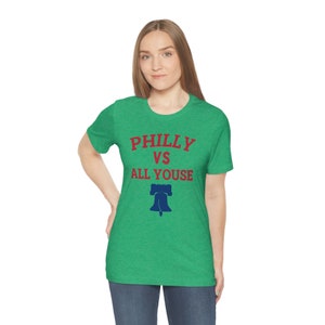 May include: A green t-shirt with the text "Philly vs All Youse" in red and a blue Liberty Bell graphic.