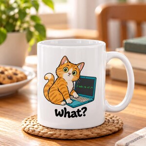 Op de afbeelding: Een witte keramische mok met een cartoon van een oranje cyperse kat voor een blauwgroene laptop. Op het scherm staat de opdracht $ sudo rm -rf /* en het woord What? is in zwarte letters onder de kat gedrukt.