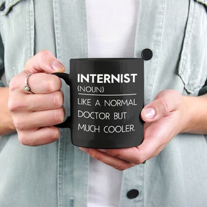 Peut inclure: Mug &agrave; caf&eacute; noir avec du texte blanc qui dit "Internist (nom) Comme un m&eacute;decin normal mais beaucoup plus cool."