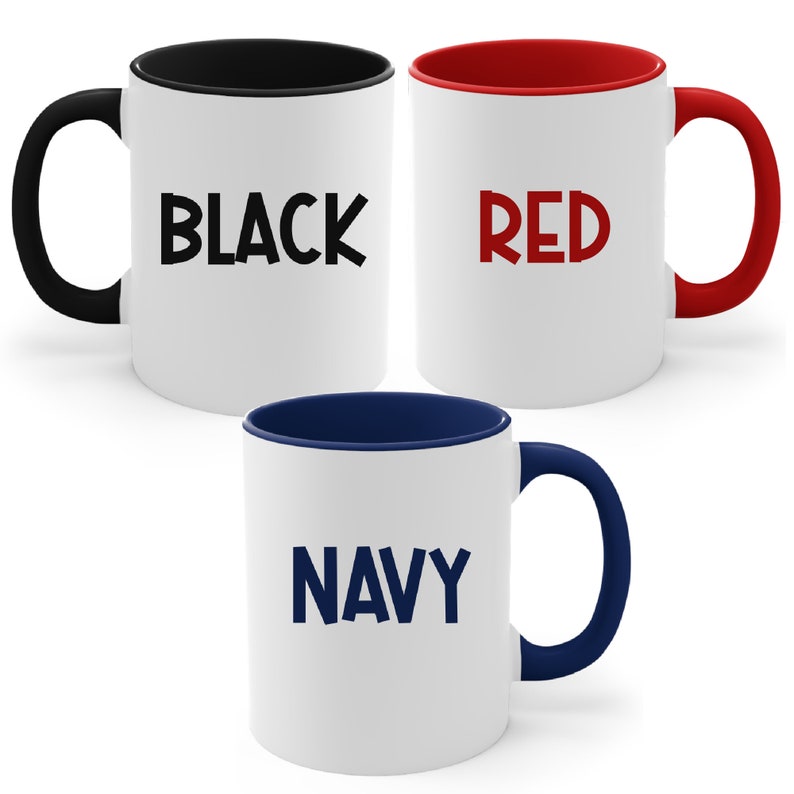 May include: Three white ceramic mugs with colored interiors and handles. One mug has a black interior and handle with the word "BLACK" in large, black letters. Another has a red interior and handle with "RED". The third has a navy interior and handle with "NAVY".