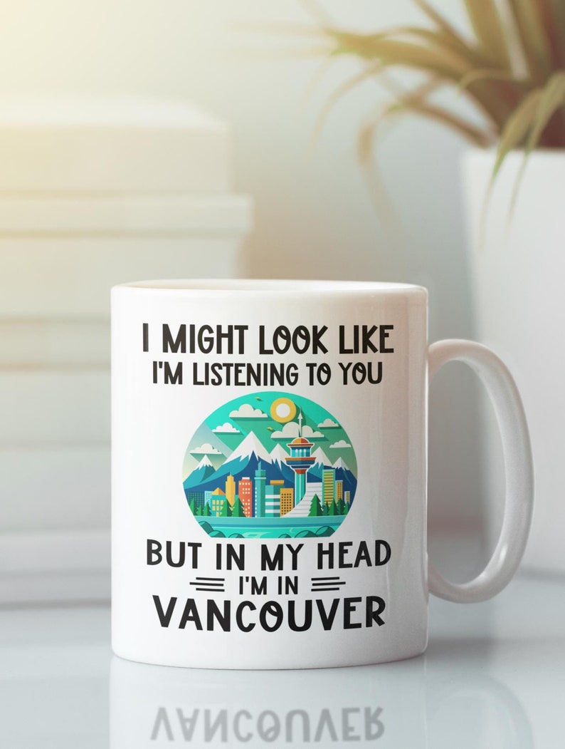 May include: White ceramic coffee mug with a black graphic that says "I might look like I'm listening to you, but in my head I'm in Vancouver". The graphic also includes a stylized illustration of the Vancouver skyline.