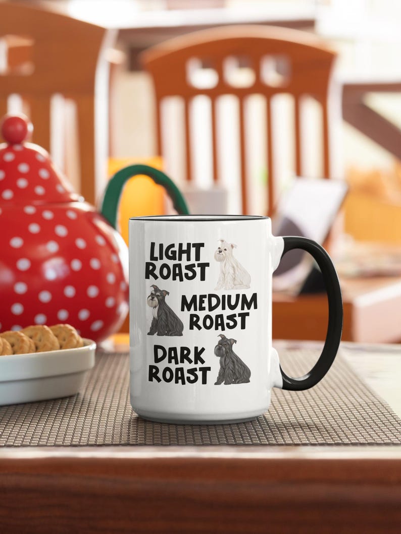 May include: White ceramic mug with a black handle. The mug has a graphic of three miniature schnauzers with the text "Light Roast", "Medium Roast", and "Dark Roast" underneath each dog.