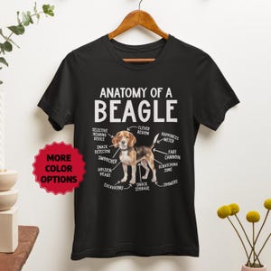 Könnte beinhalten: Schwarzes T-Shirt mit einer weißen Grafik eines Beagle-Hundes mit dem Text "Anatomie eines Beagles" und einer Liste von Hundefähigkeiten und Verhaltensweisen.