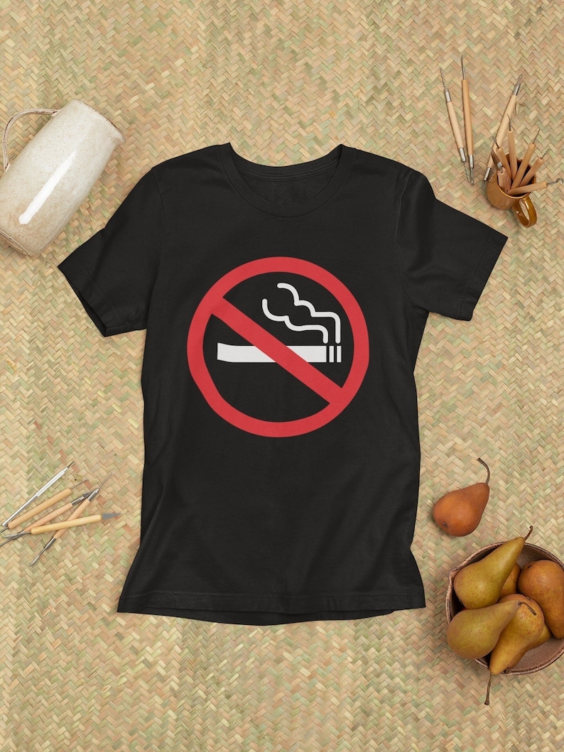 May include: Black t-shirt with a red circle and a diagonal line through a white cigarette with smoke. The text "No Smoking" is not visible in the image.