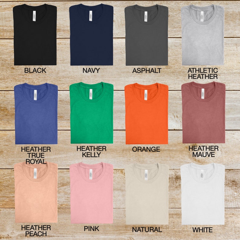 May include: A selection of t-shirts in various colors, including black, navy, asphalt, athletic heather, heather true royal, heather kelly, orange, heather mauve, heather peach, pink, natural, and white.