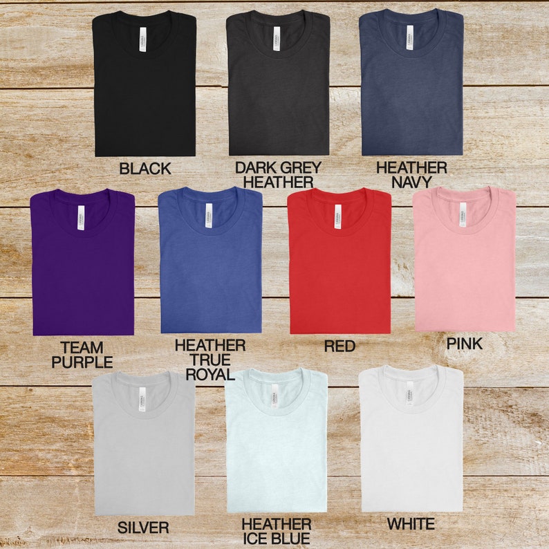 May include: A selection of t-shirts in various colors, including black, dark grey heather, heather navy, team purple, heather true royal, red, pink, silver, heather ice blue, and white.