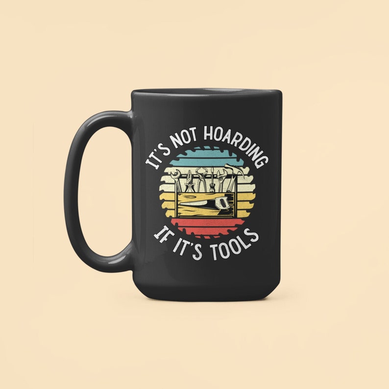 May include: Black coffee mug with a white graphic of a toolbox with tools and the text "It's not hoarding if it's tools" in a retro style.